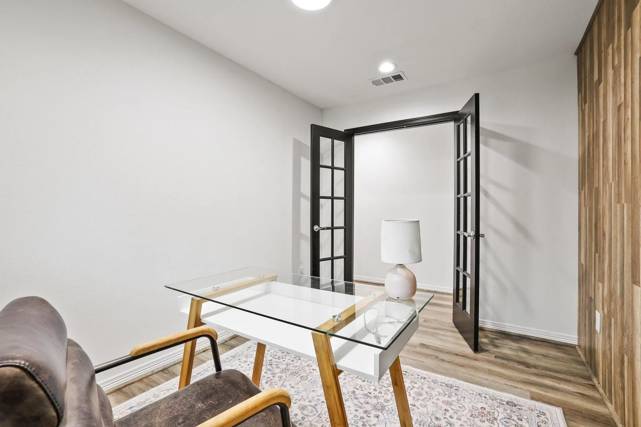 Wood-finish flooring, recessed lighting, and a textured wood-panel accent wall