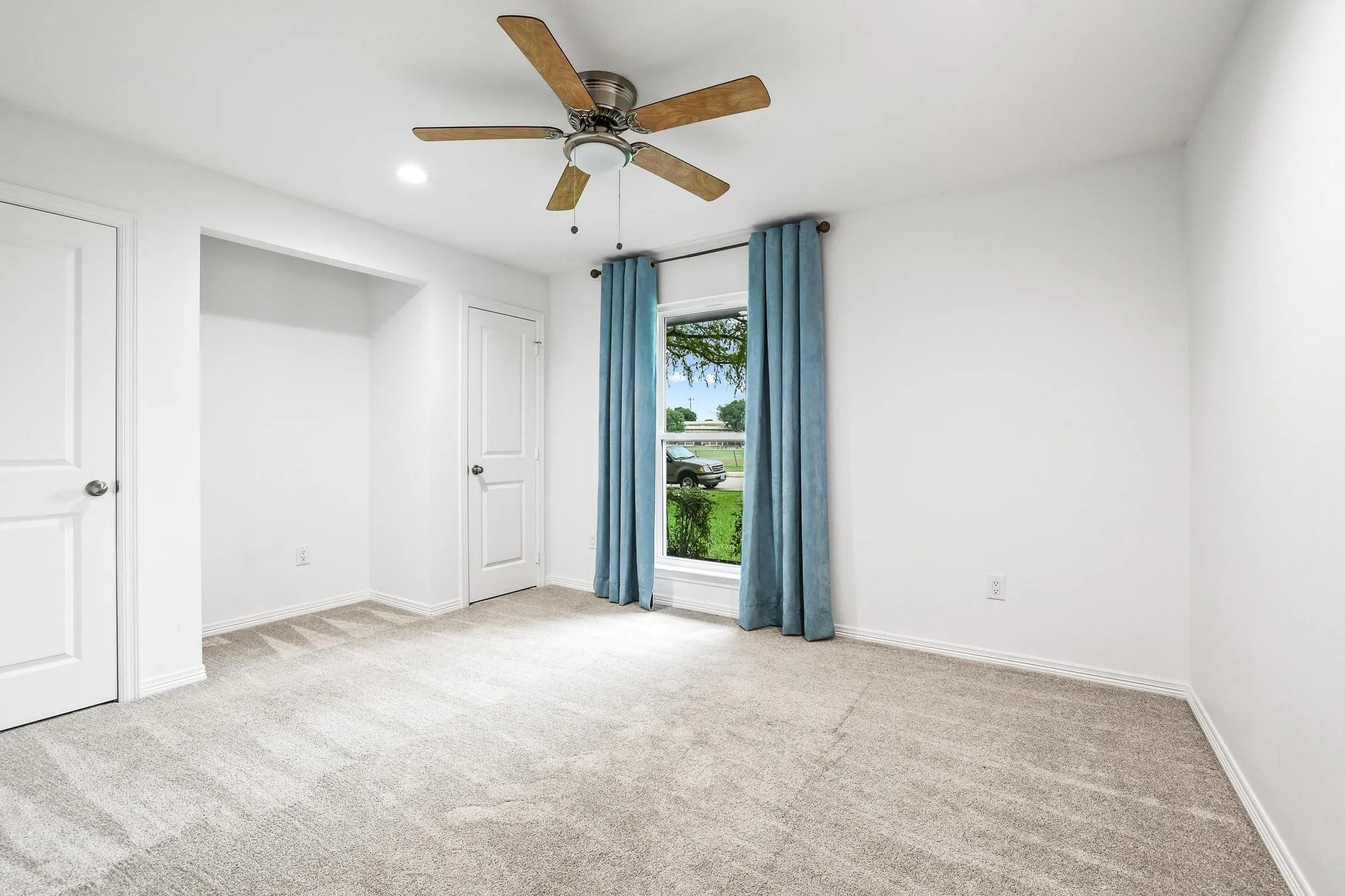 Downstairs Bedroom 3, Neutral tone carpeting, white walls, ceiling fan with light, recessed lighting, and a window with a white frame