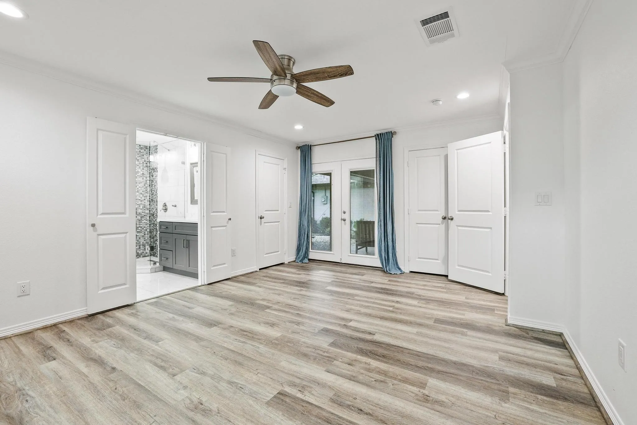 Wood-finish flooring throughout, ceiling fan, recessed lighting, and French doors