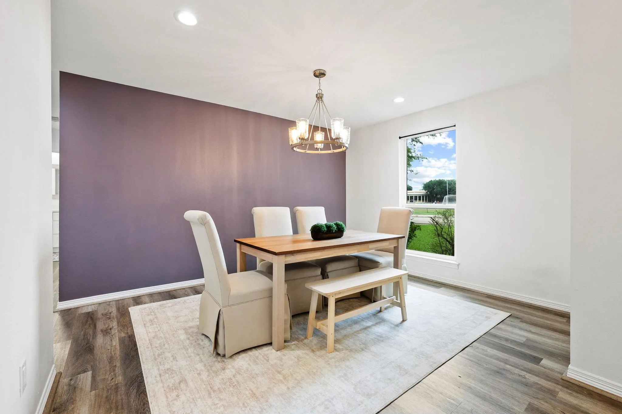 Contemporary chandelier, wood-finish flooring, accent wall, white trim