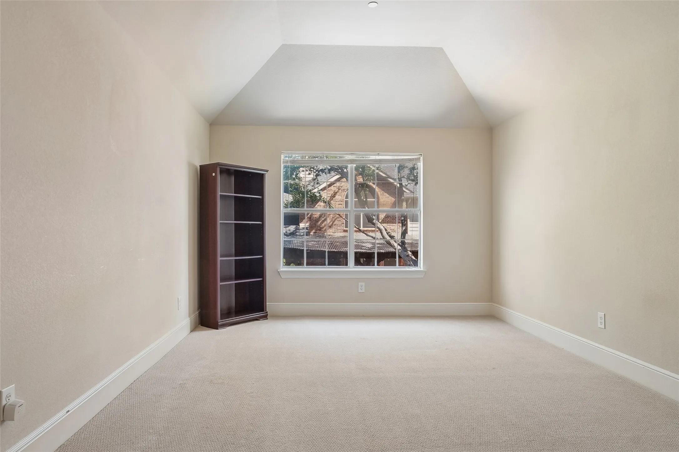 Recessed ceiling with an angled design, light neutral wall paint, and plush carpeting