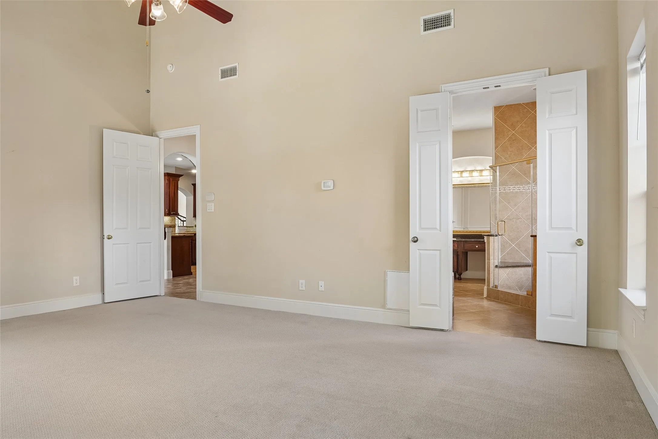 Spacious room with vaulted ceilings and a ceiling fan