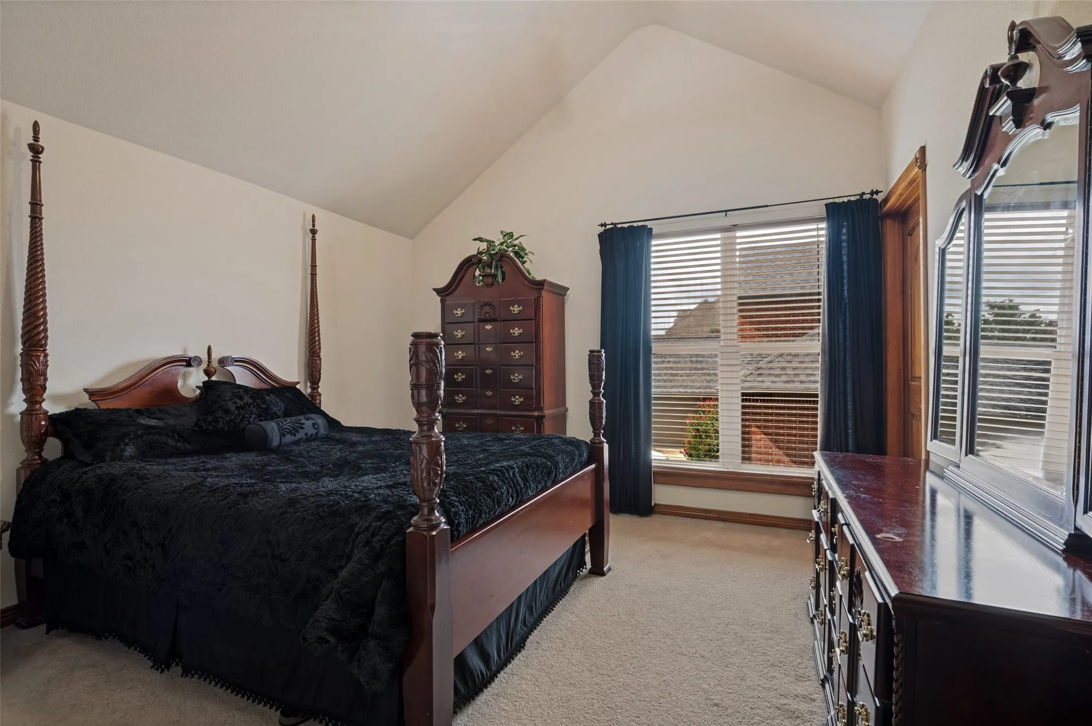 Upstairs bedroom with a vaulted ceiling and a large window