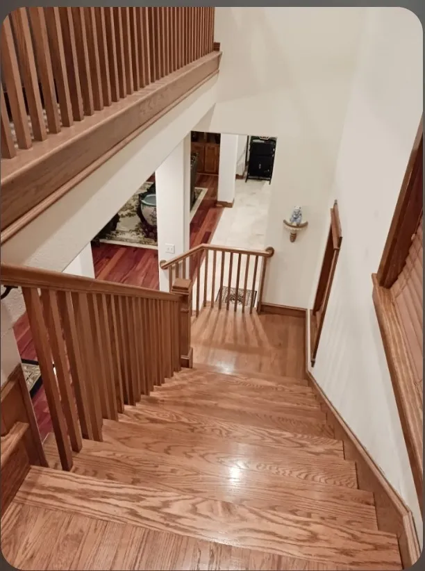 Hardwood staircase with a custom railing and a landing that overlooks the main floor