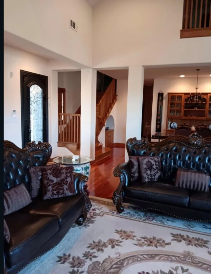 Open family room with an iron front door, an upstairs overlook, and a view to the dining room