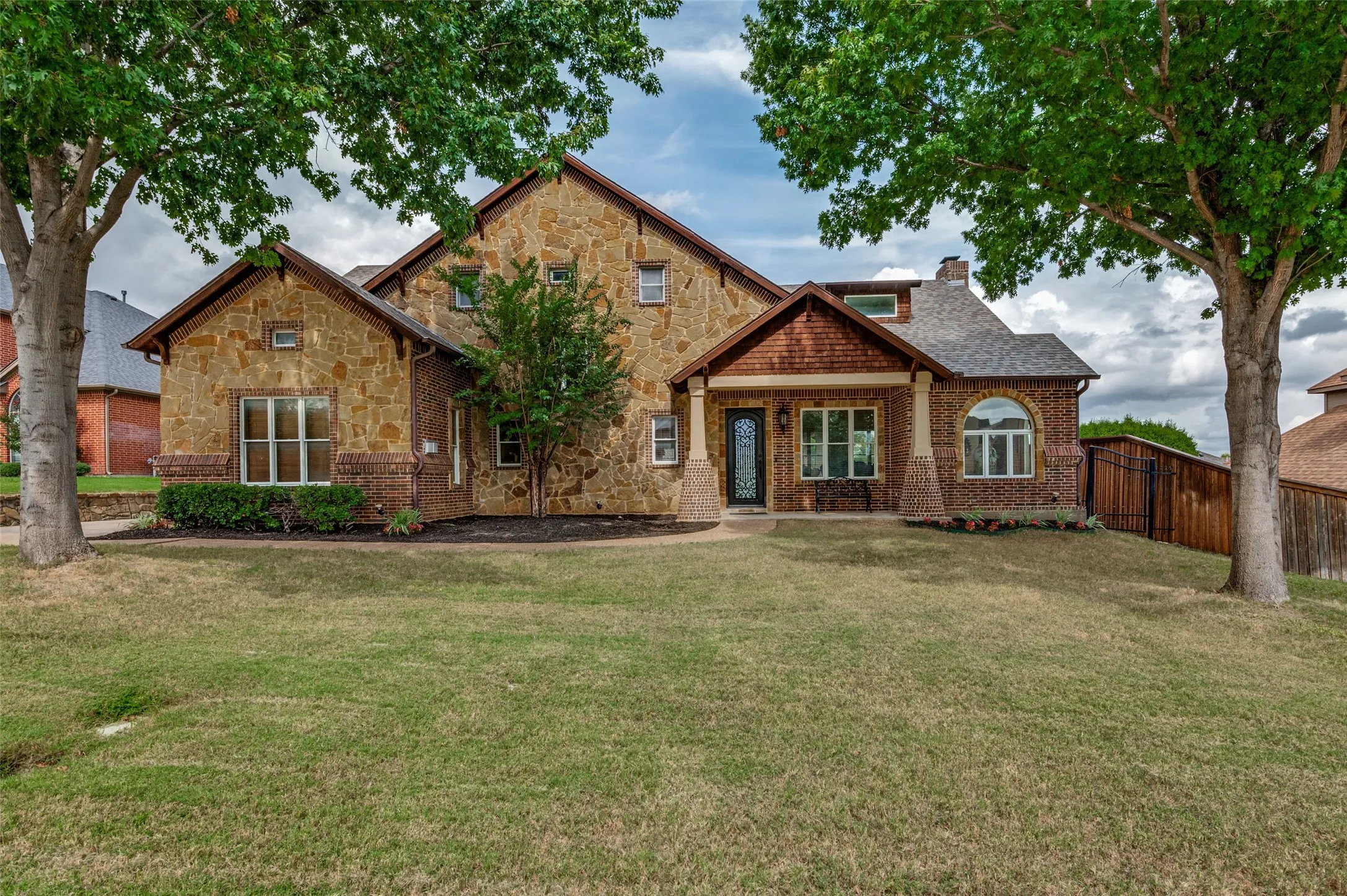 Brick and stone front elevation on a quiet cul-de-sac with mature shade trees