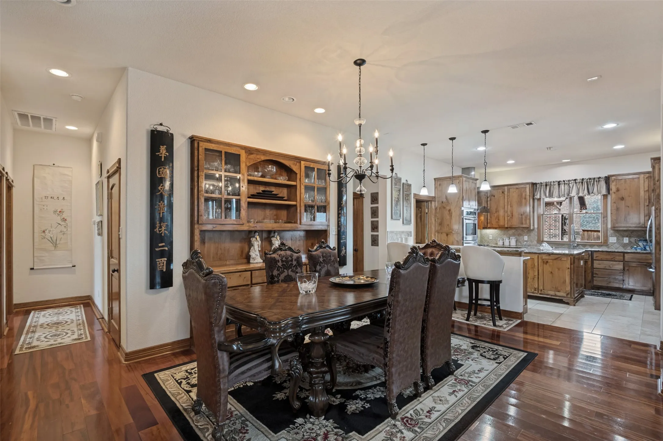 Formal dining with a chandelier and built-in China hutch, open to the kitchen
