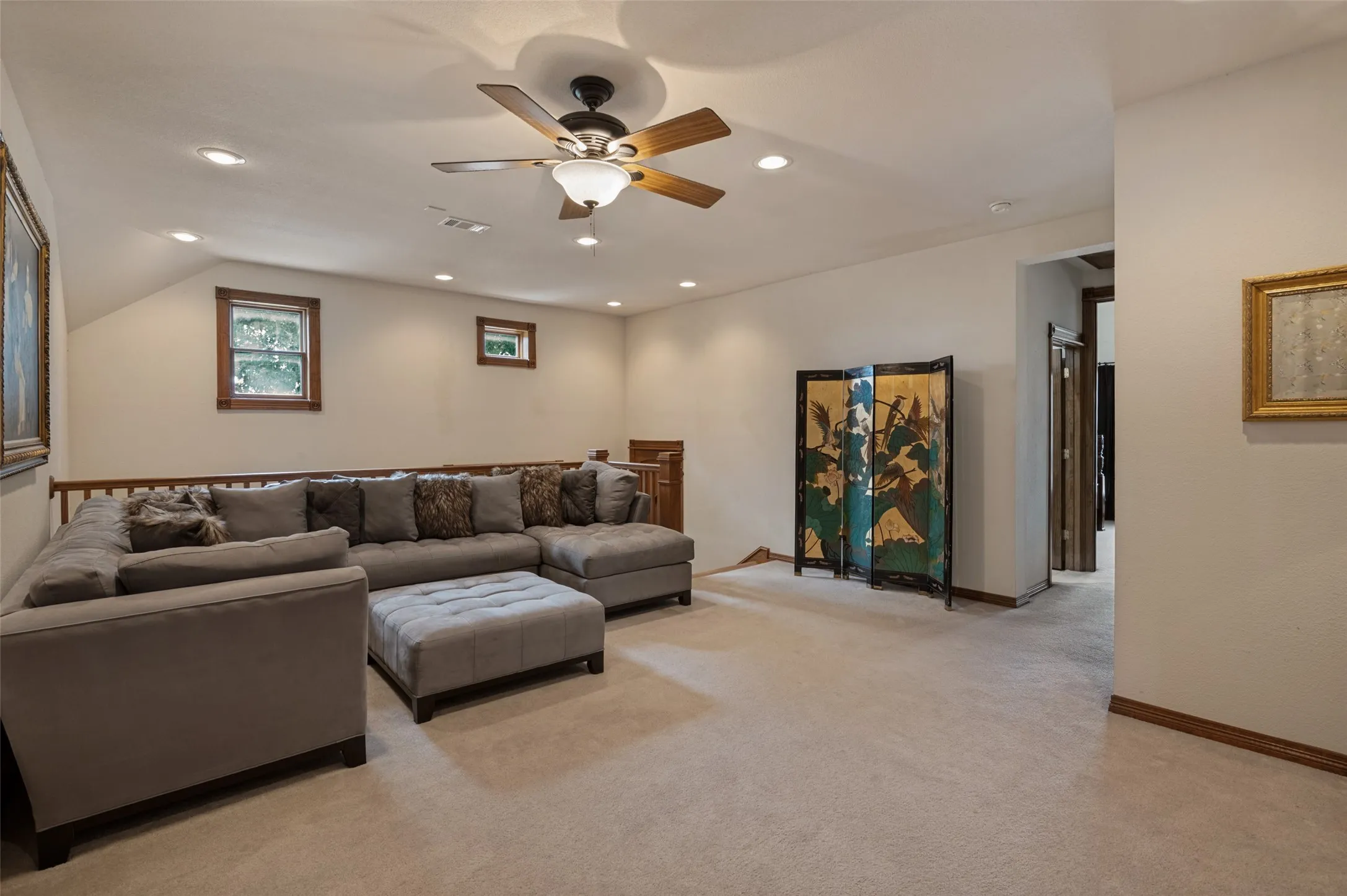 Upstairs game room with a ceiling fan and plush carpet
