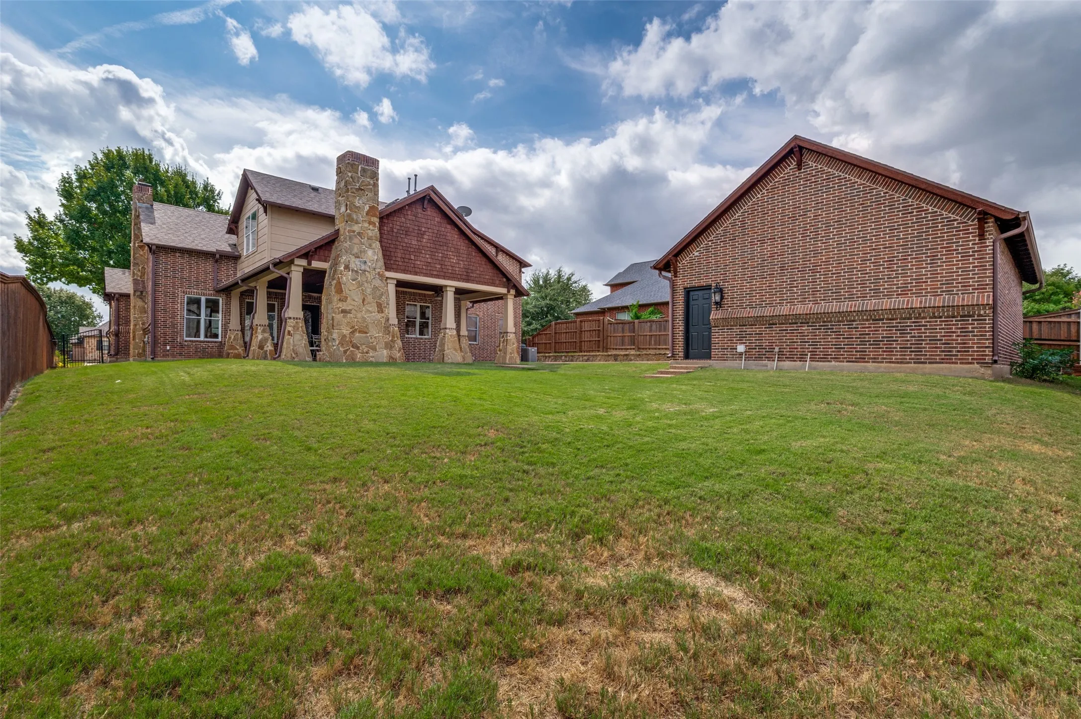 Large backyard with a view of the covered patio and garage