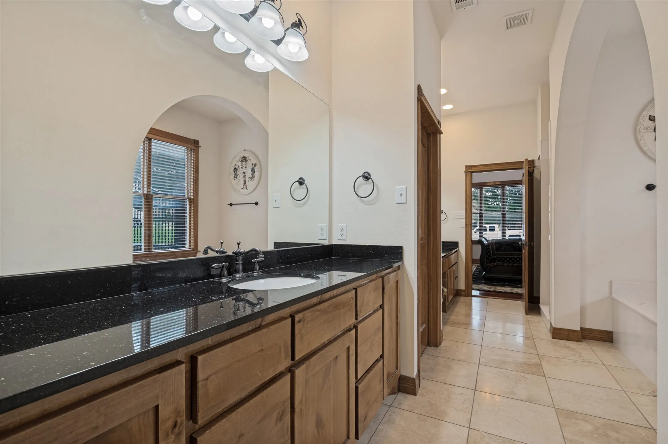 Primary bath with long granite vanities and dual sinks