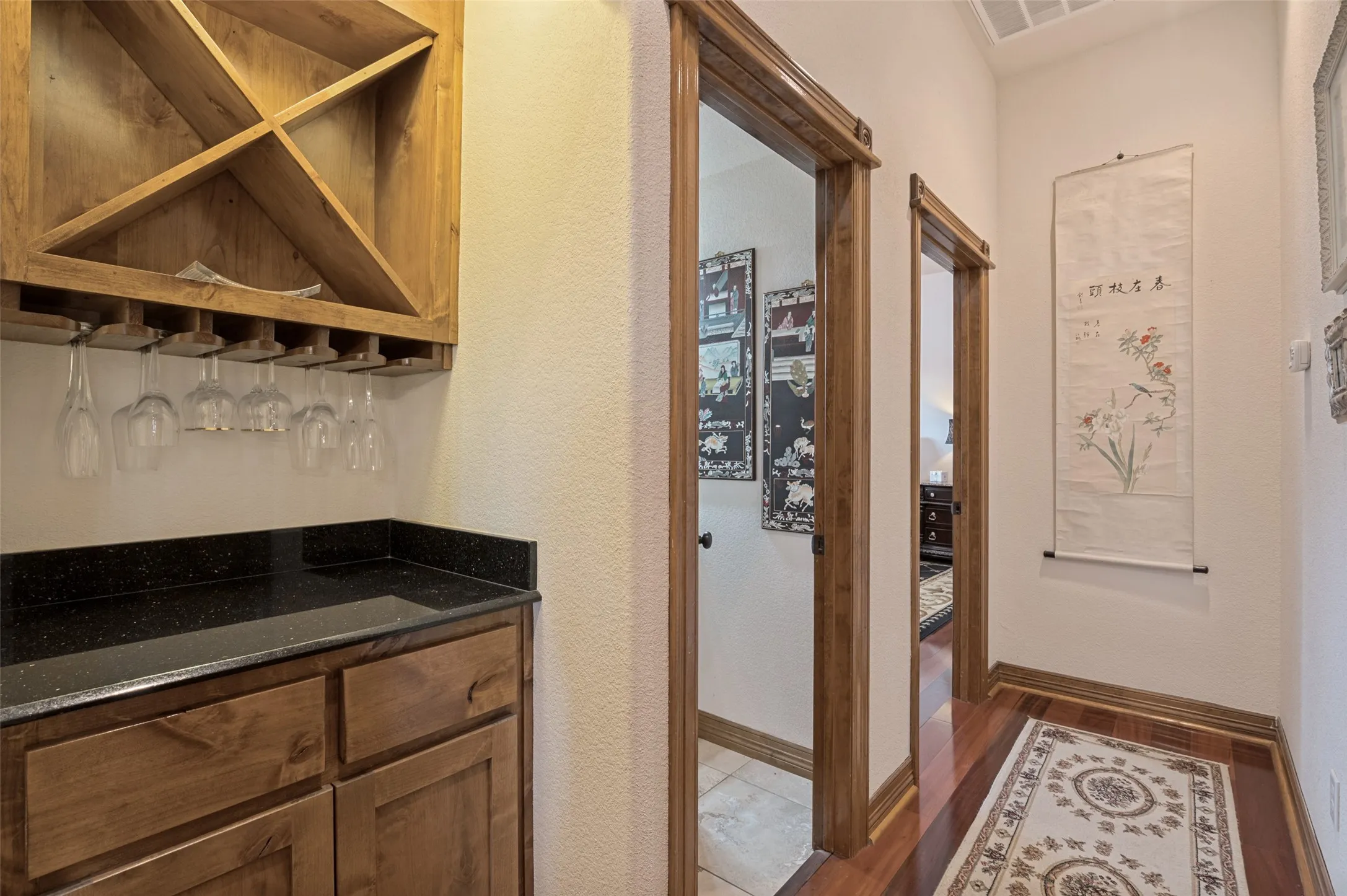 Dry bar with a granite counter, wine rack, and stemware storage