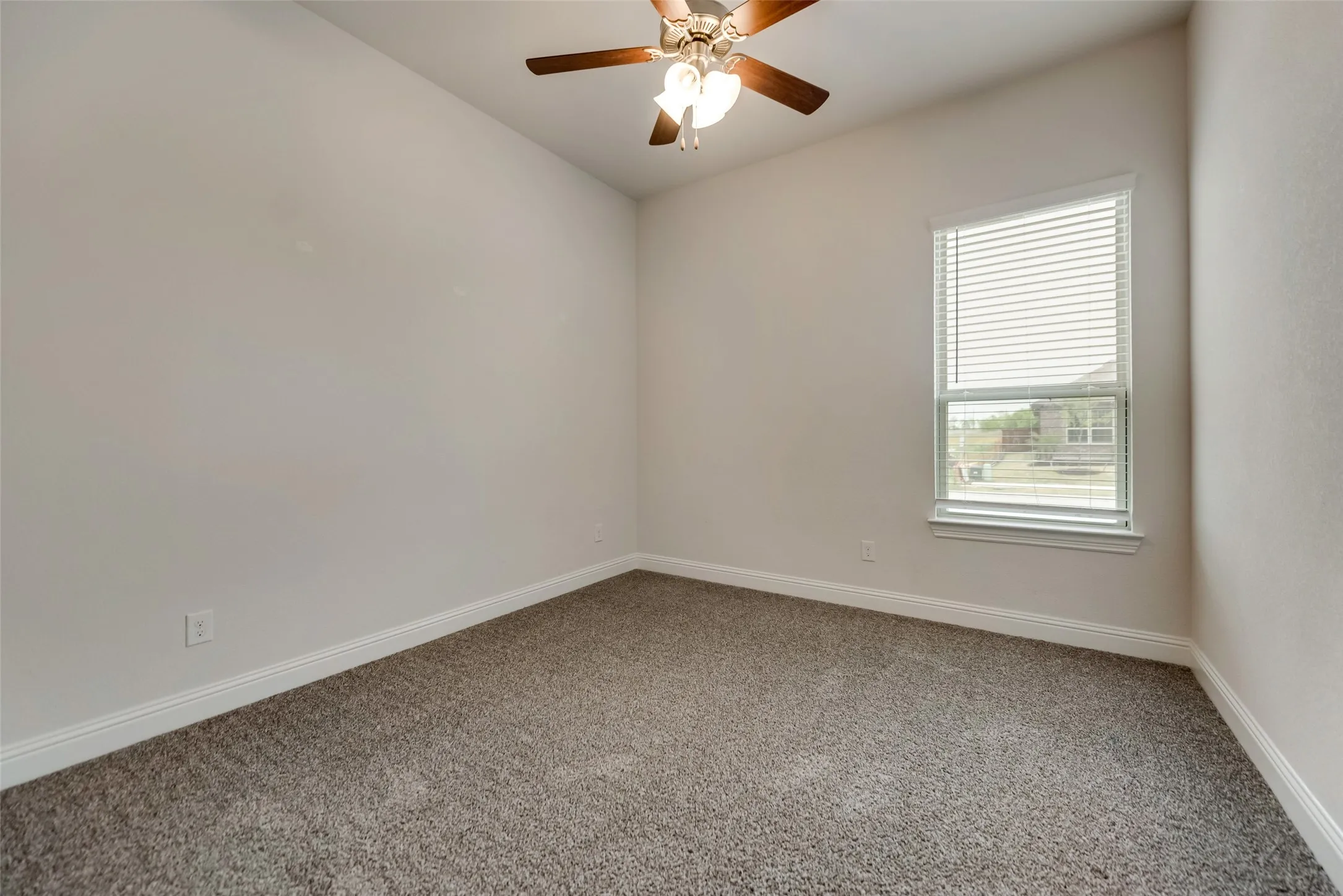 Vaulted ceiling with a ceiling fan, neutral wall color, carpeted flooring, and a window with blinds