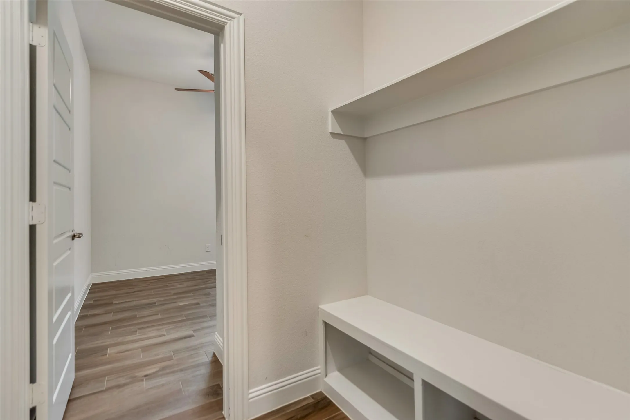 Built-in entryway bench with storage cubbies and an overhead shelf
