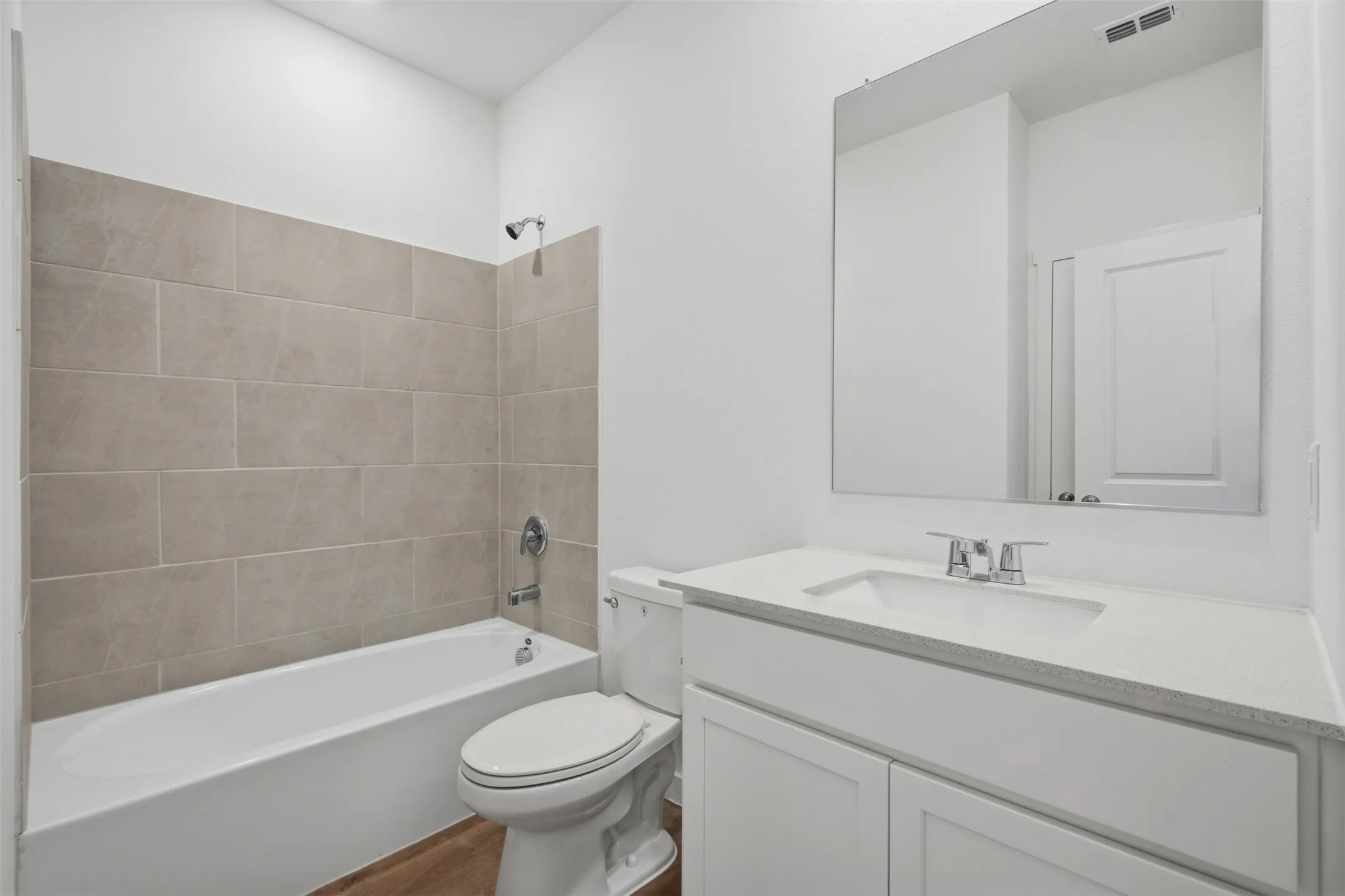 White vanity with a solid surface countertop, undermount sink, and chrome faucet