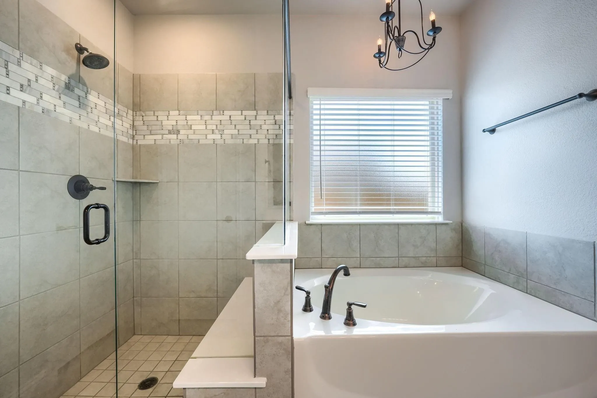 Tiled walk-in shower with glass enclosure and built-in bench