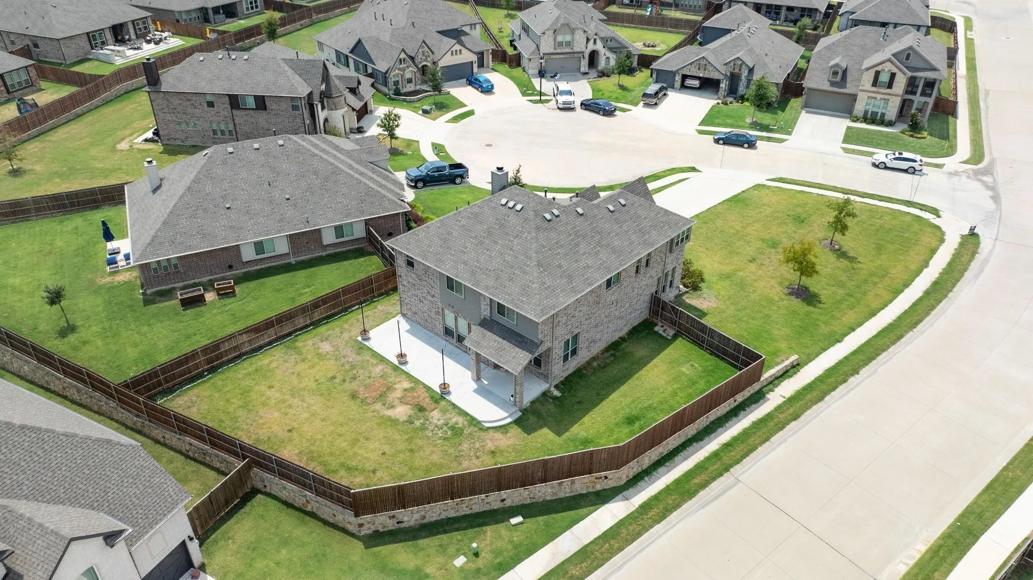 Two-story residence featuring a brick and siding exterior, private fenced yard, and an outdoor patio