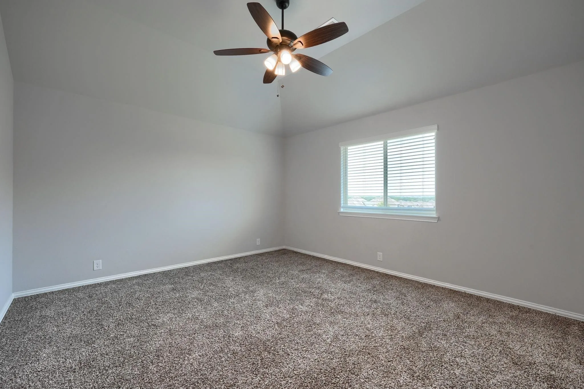 Vaulted ceiling with an attached ceiling fan and light fixture
