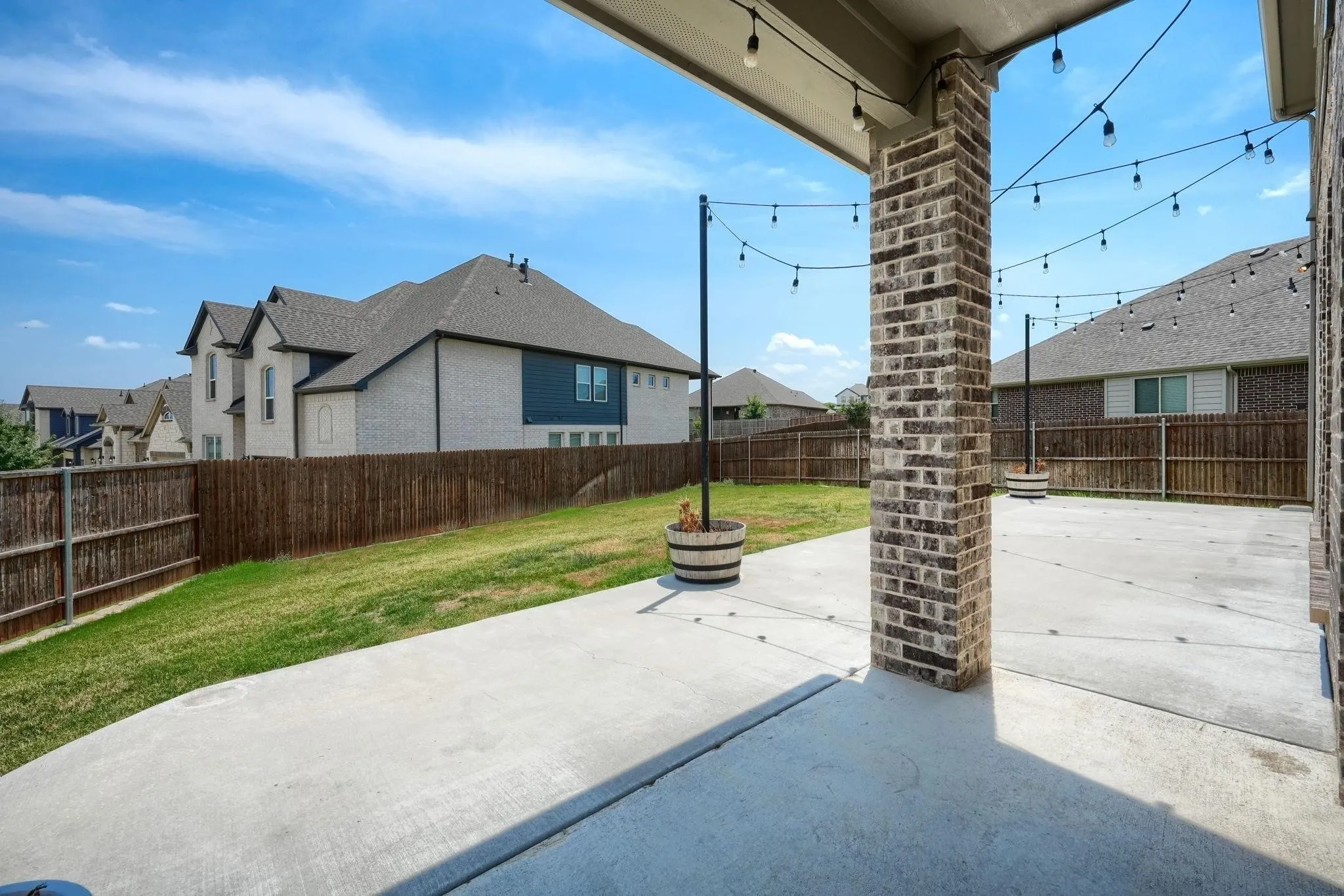 Covered patio featuring concrete flooring and a brick support column