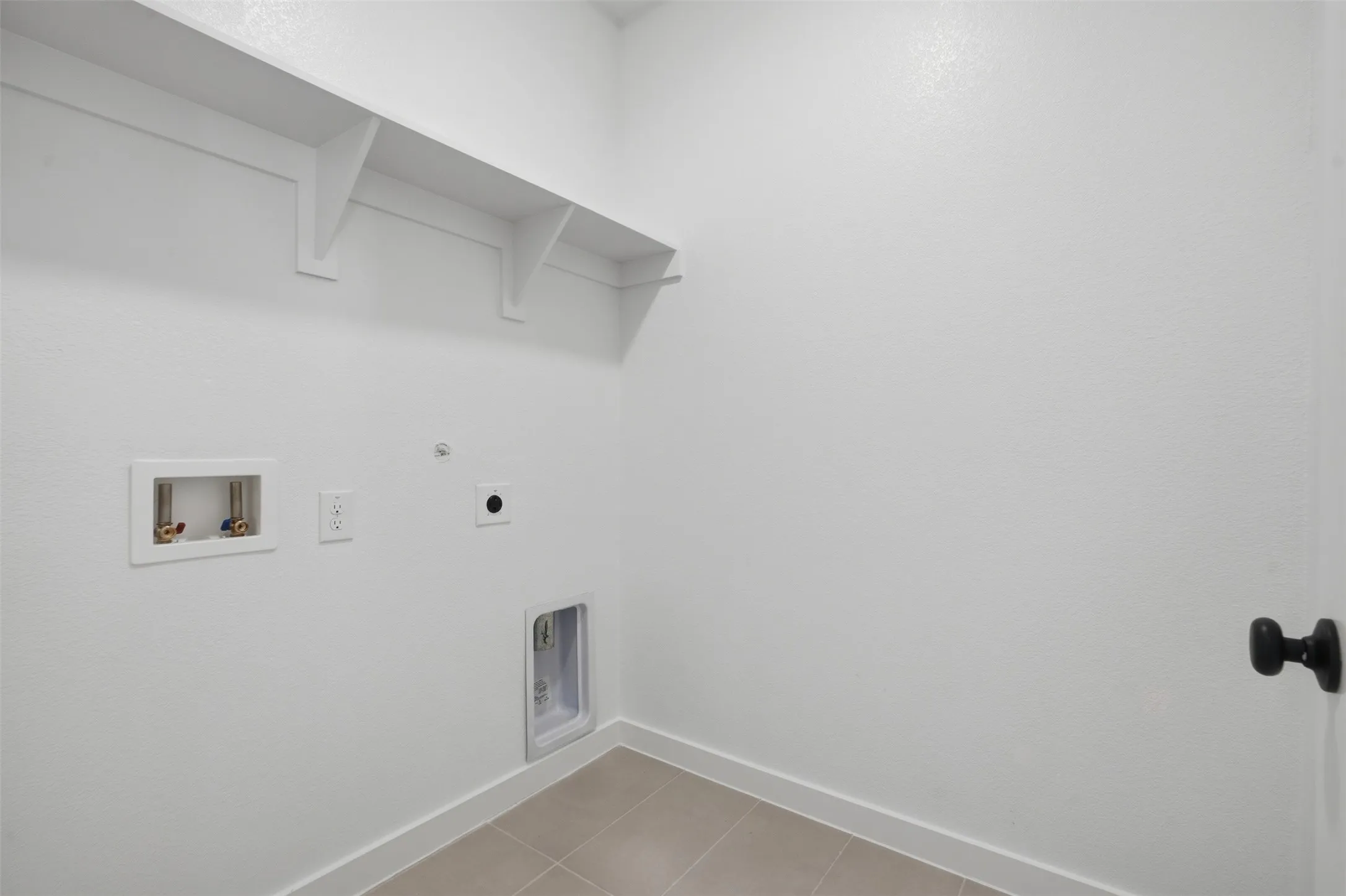 Laundry area with built-in shelving, tile flooring, and utility hookups