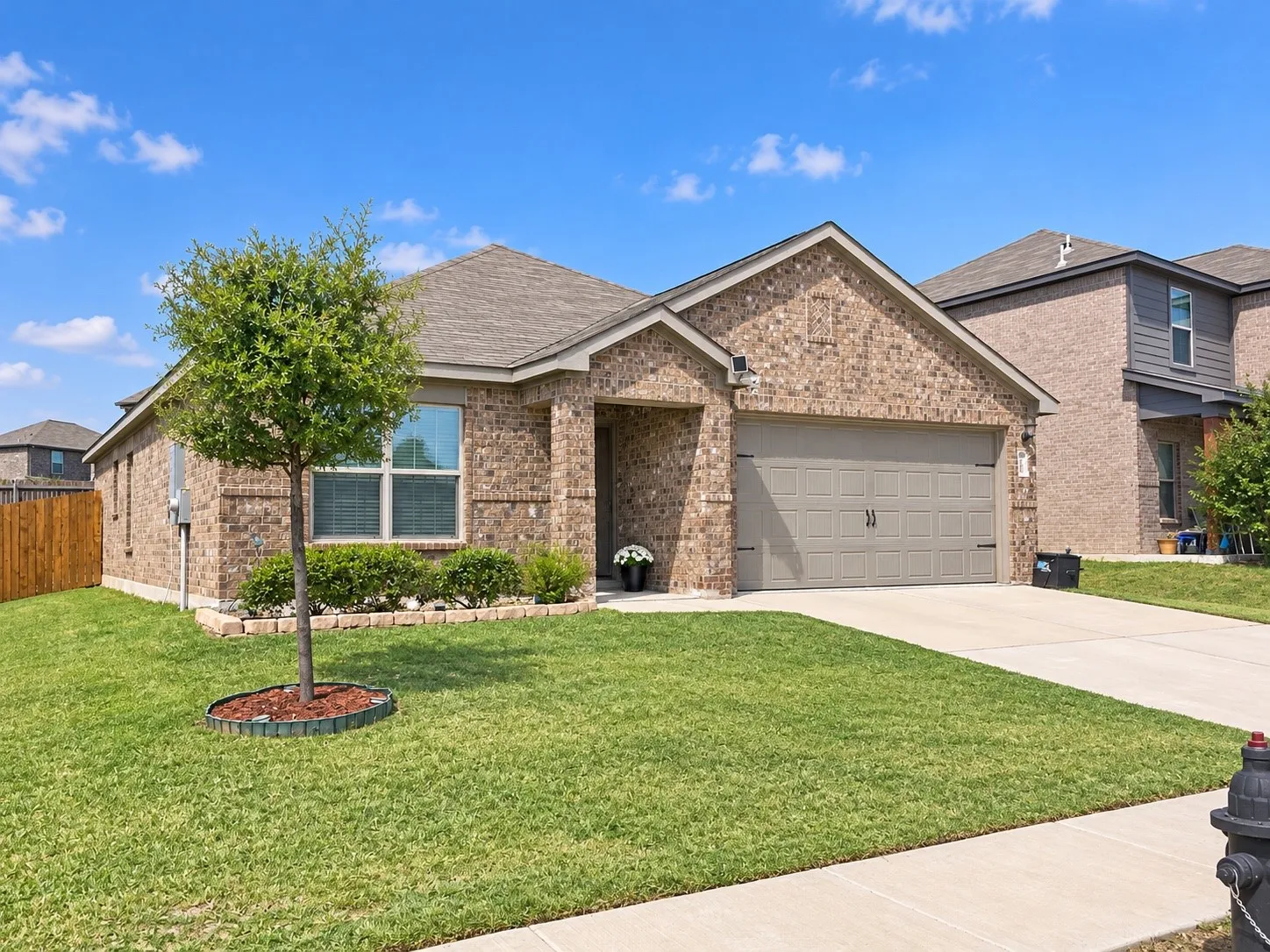 Brick exterior with a gabled roofline, an attached two-car garage, and a concrete driveway