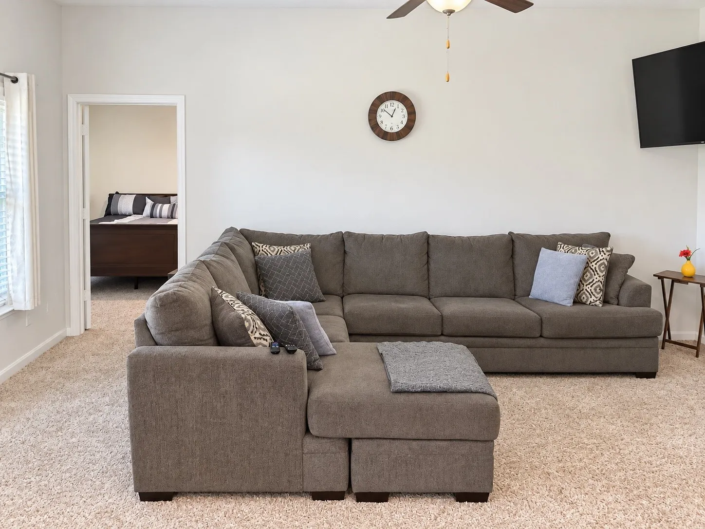 Neutral wall paint, ceiling fan with integrated lighting, and wall-to-wall carpeting
