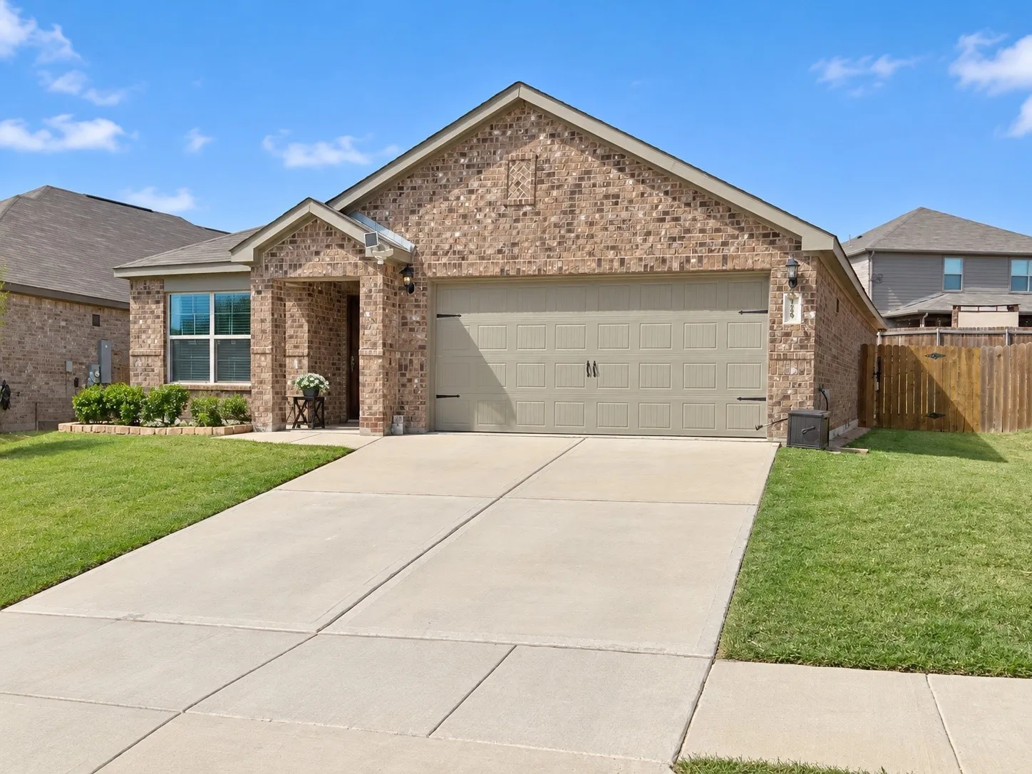 Brick exterior with a gabled roofline, an attached two-car garage, and a concrete driveway