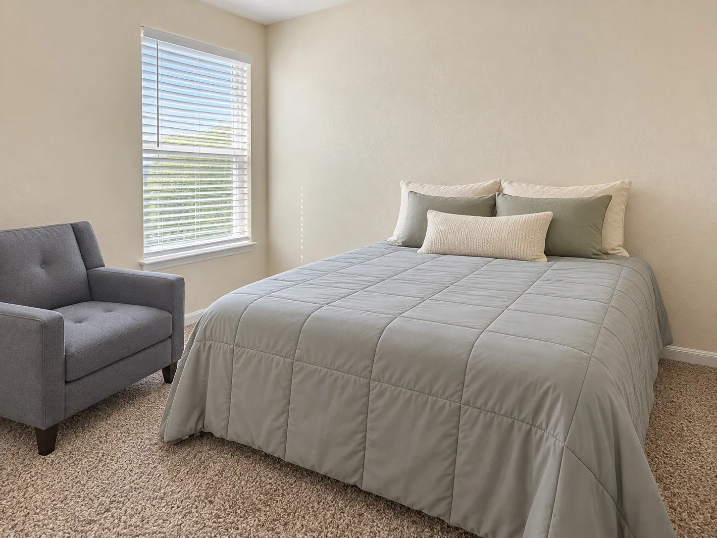 Wall-to-wall carpeting and a single window with blinds