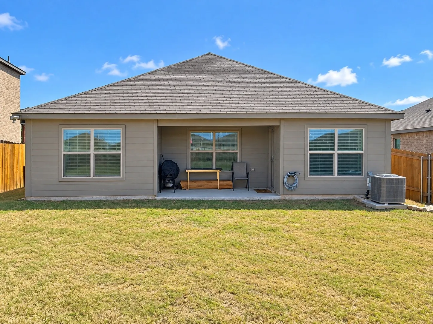 Rear exterior with covered patio, durable siding, multiple windows, and a shingled roof