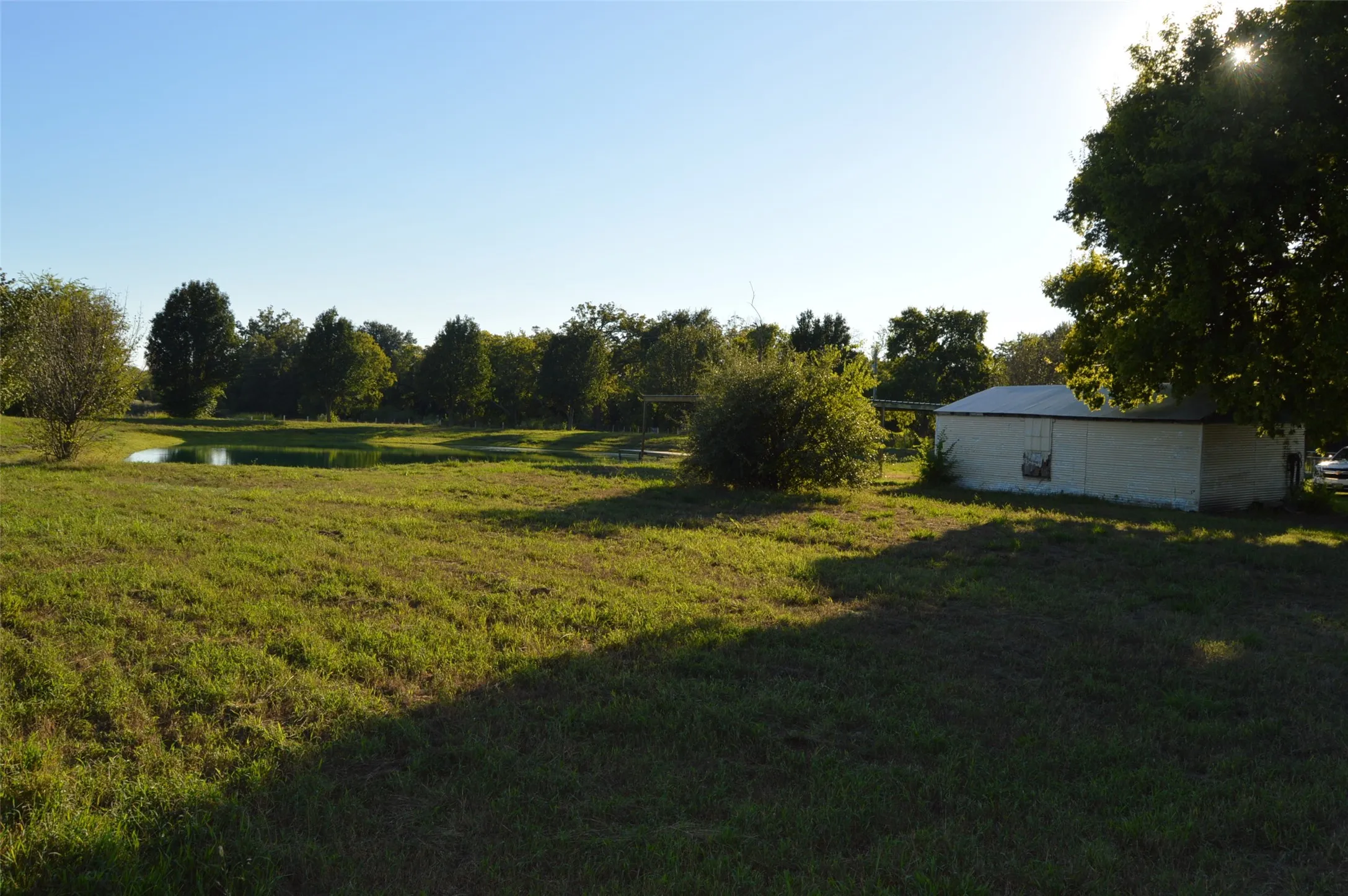 Looking at garage/shop with pond in view