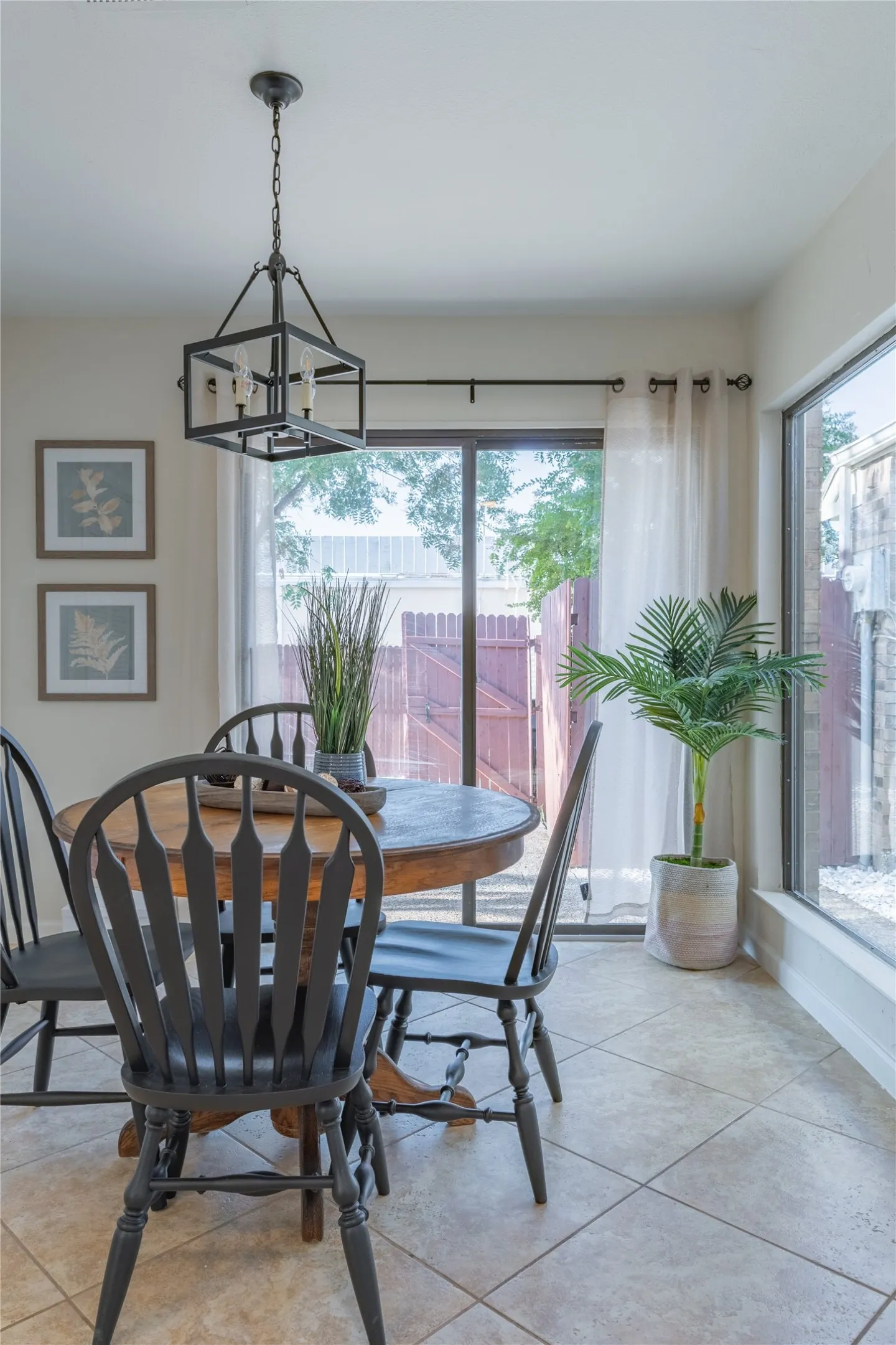 Tile flooring, sliding glass door, large window, and a built-in light fixture