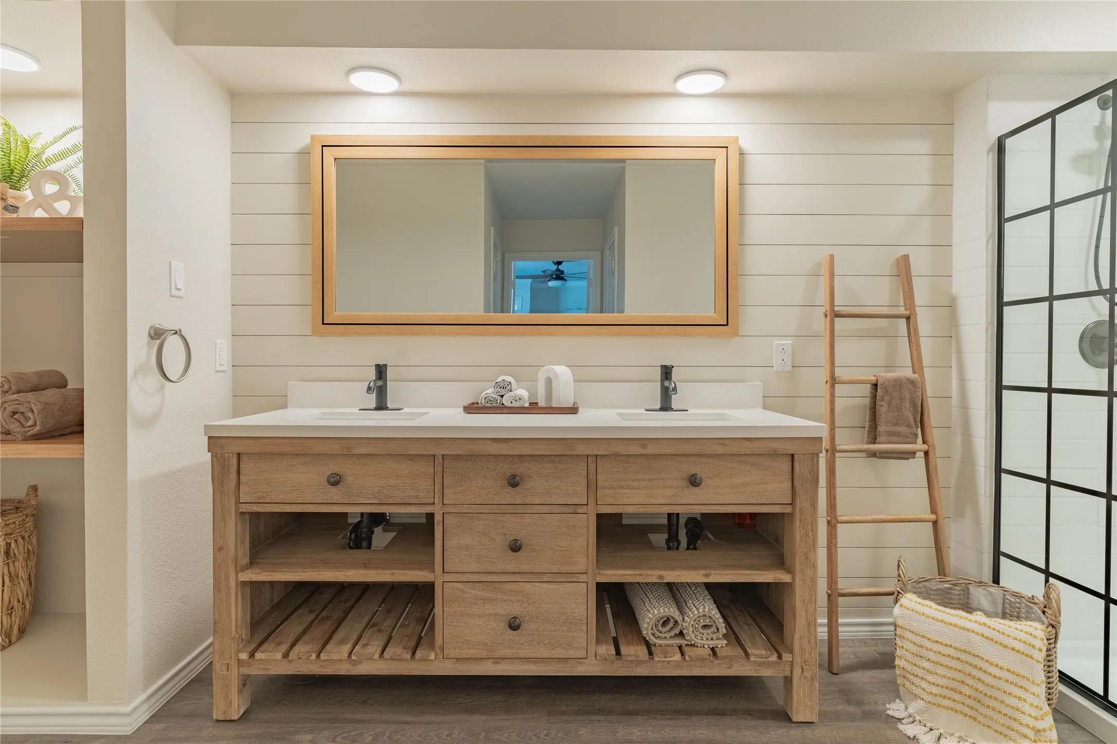 Dual vanity with quartz countertop, wood-finish cabinetry, and matte black fixtures