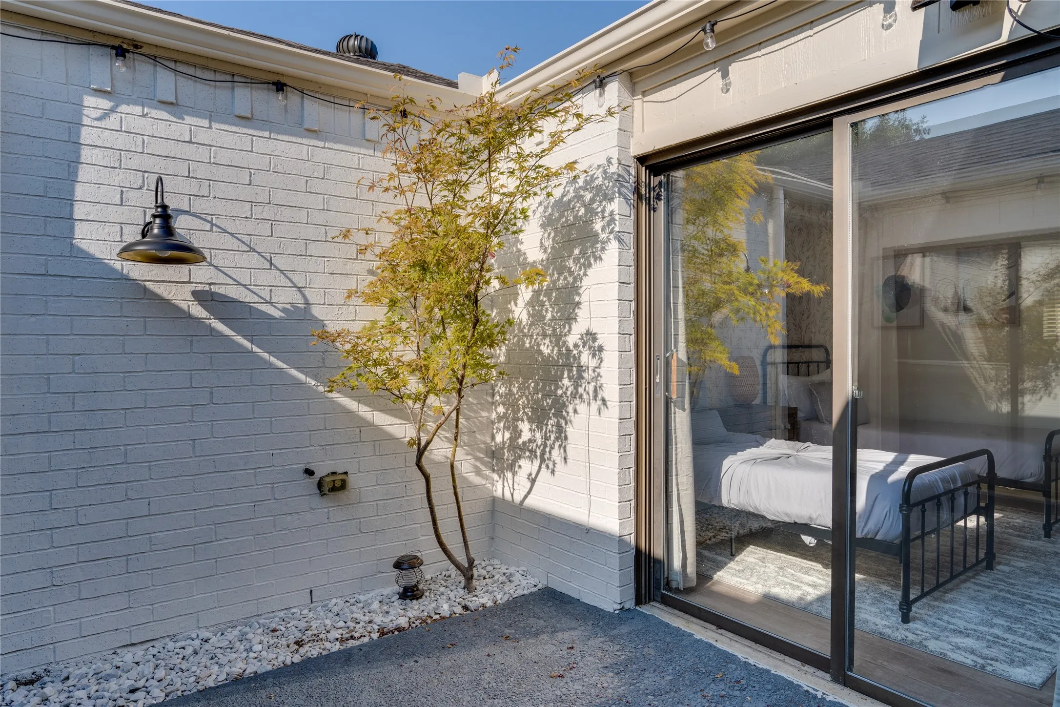 White painted brick exterior with a wall-mounted outdoor light fixture