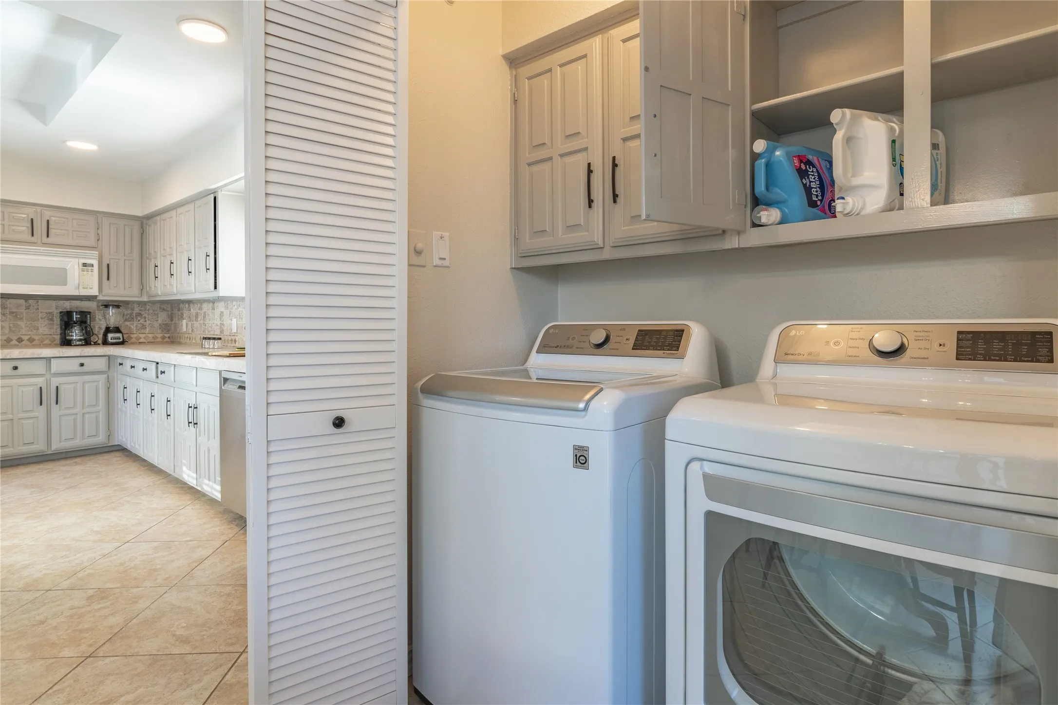 Laundry area featuring upper cabinetry and shelving