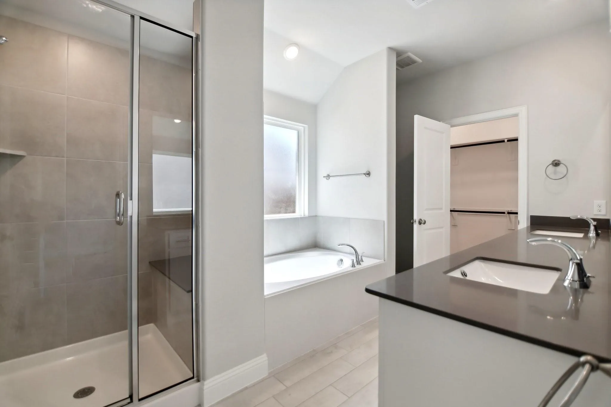 Walk-in shower with clear glass enclosure and built-in bench