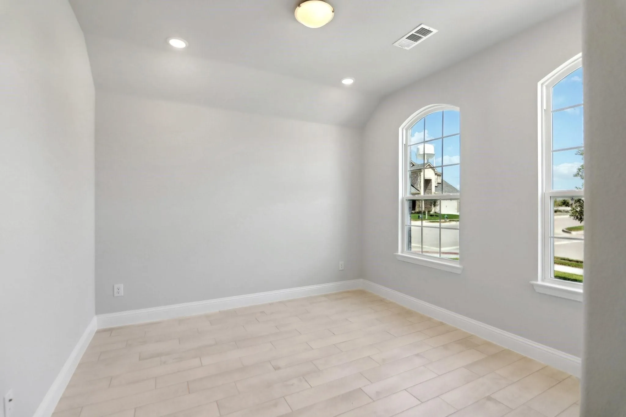 Arched windows, recessed lighting, and a neutral color palette