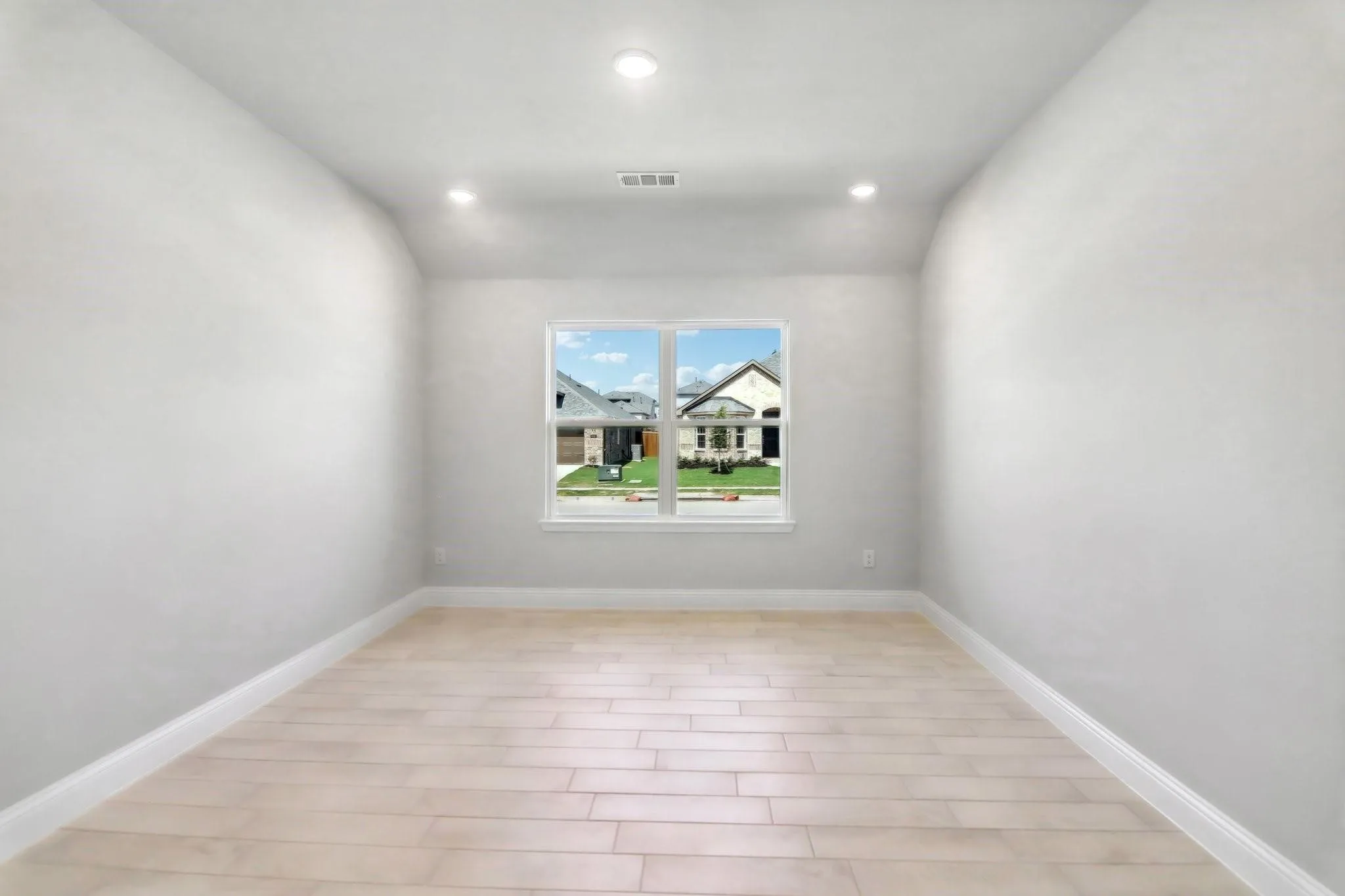 Recessed ceiling lighting, light wood-finish flooring, and a single window