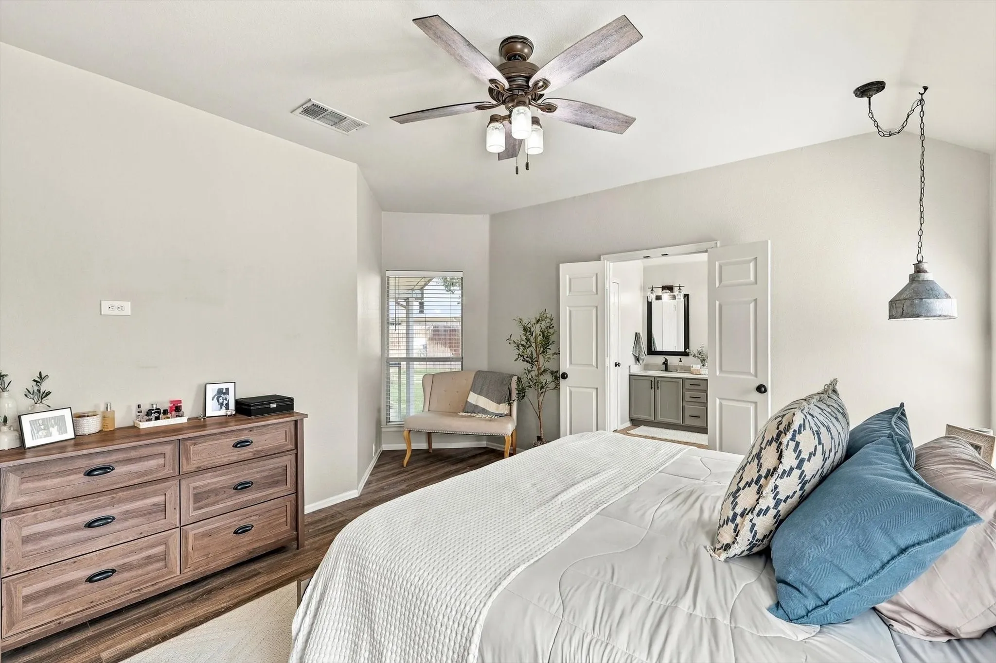 Wood-finish flooring throughout, ceiling fan with light fixture, and a window with blinds