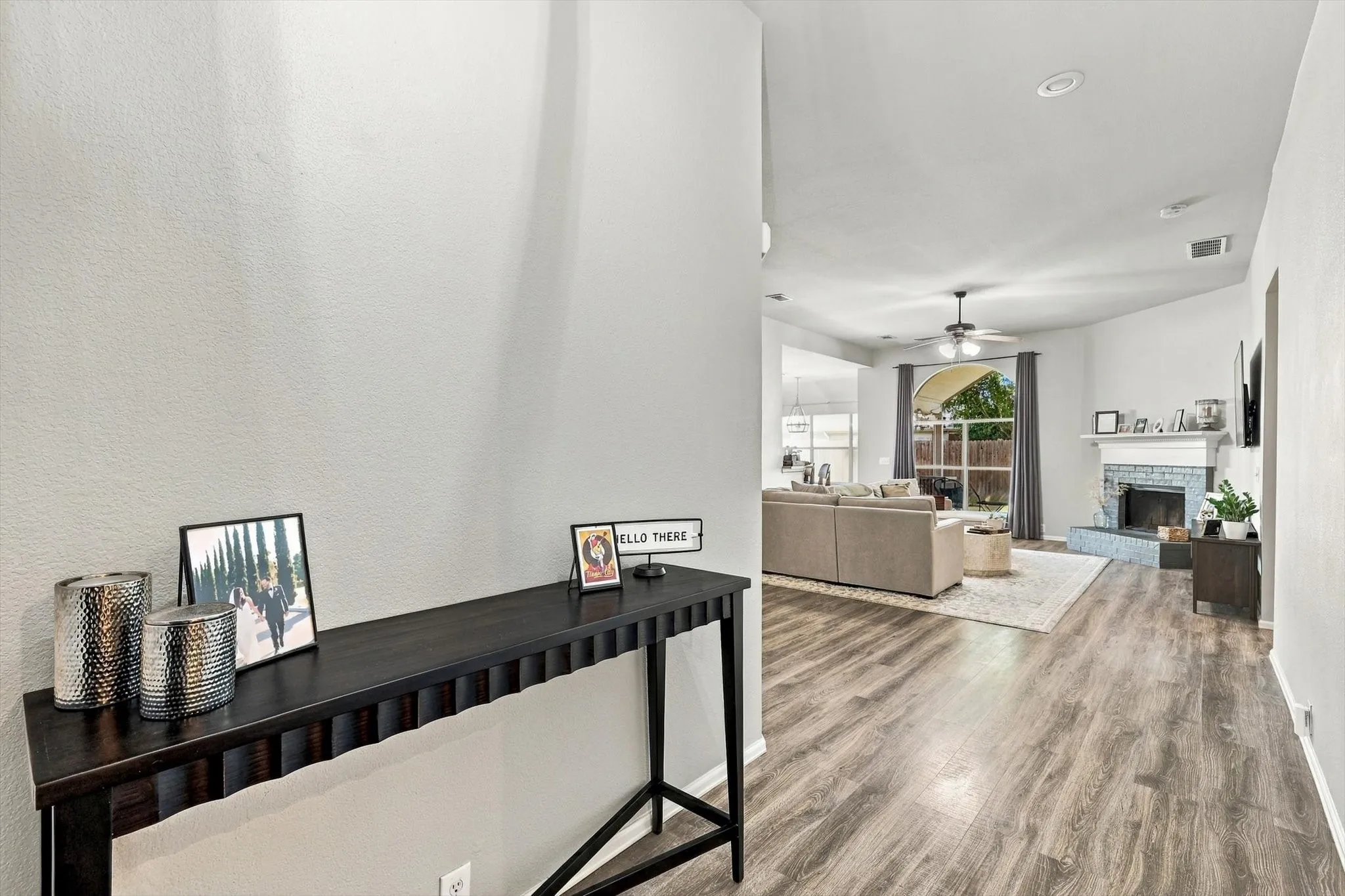 Wood-finish flooring throughout, recessed lighting, and a ceiling fan in the living area