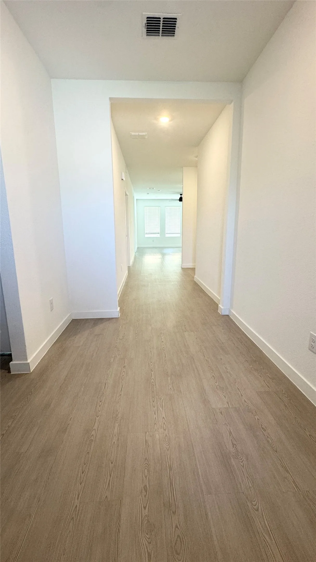 Wood-finish flooring throughout, recessed ceiling lighting, and white wall finishes