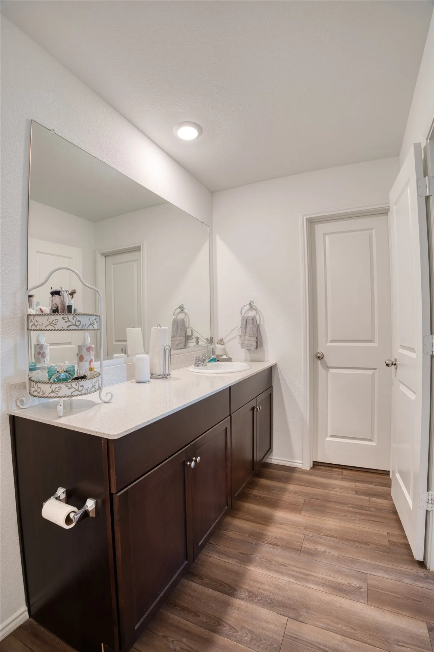 Dual vanity with dark wood-finish cabinetry, light-toned countertop, and undermount sinks