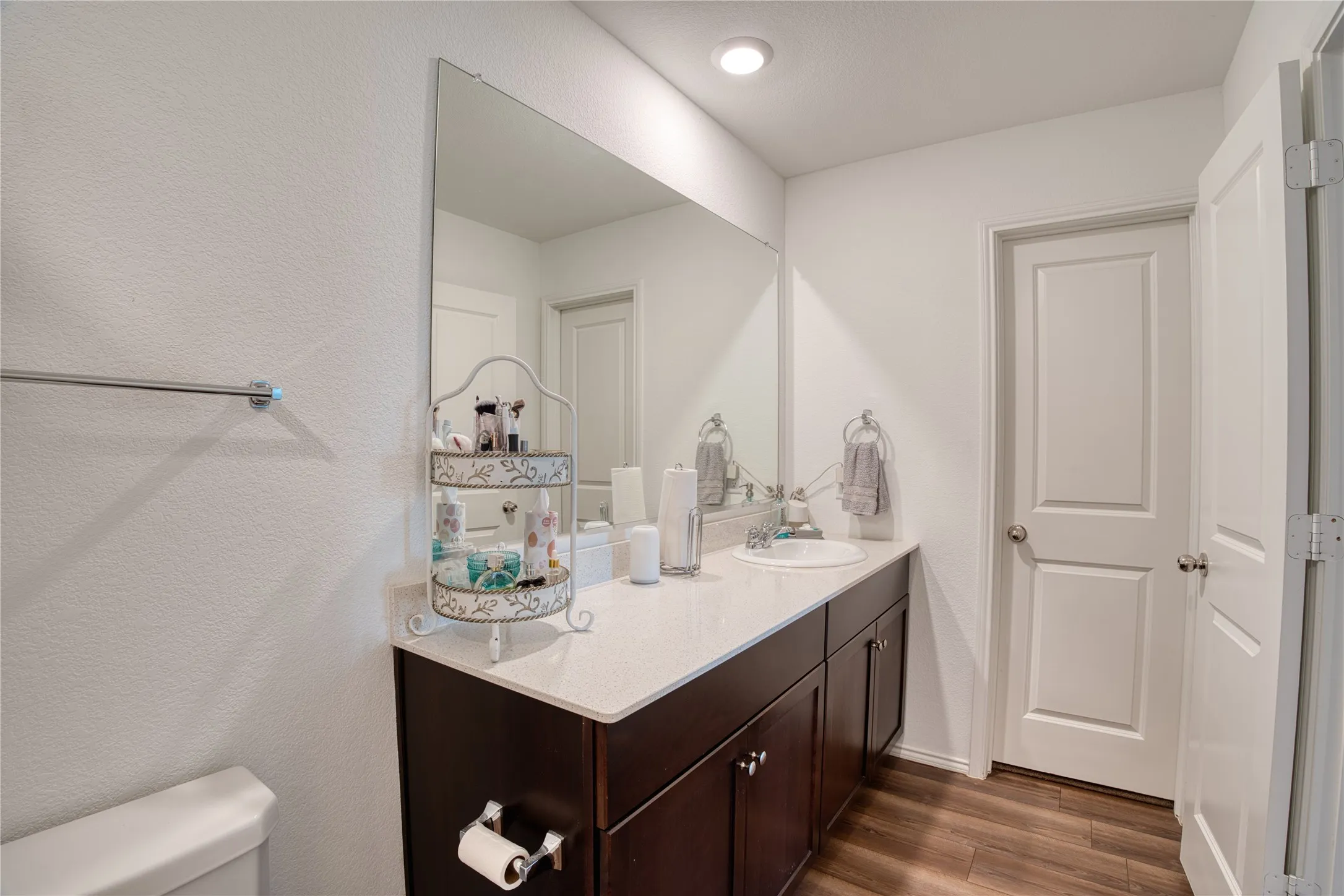 Vanity with an integrated sink, quartz countertop, and dark wood-finish cabinetry