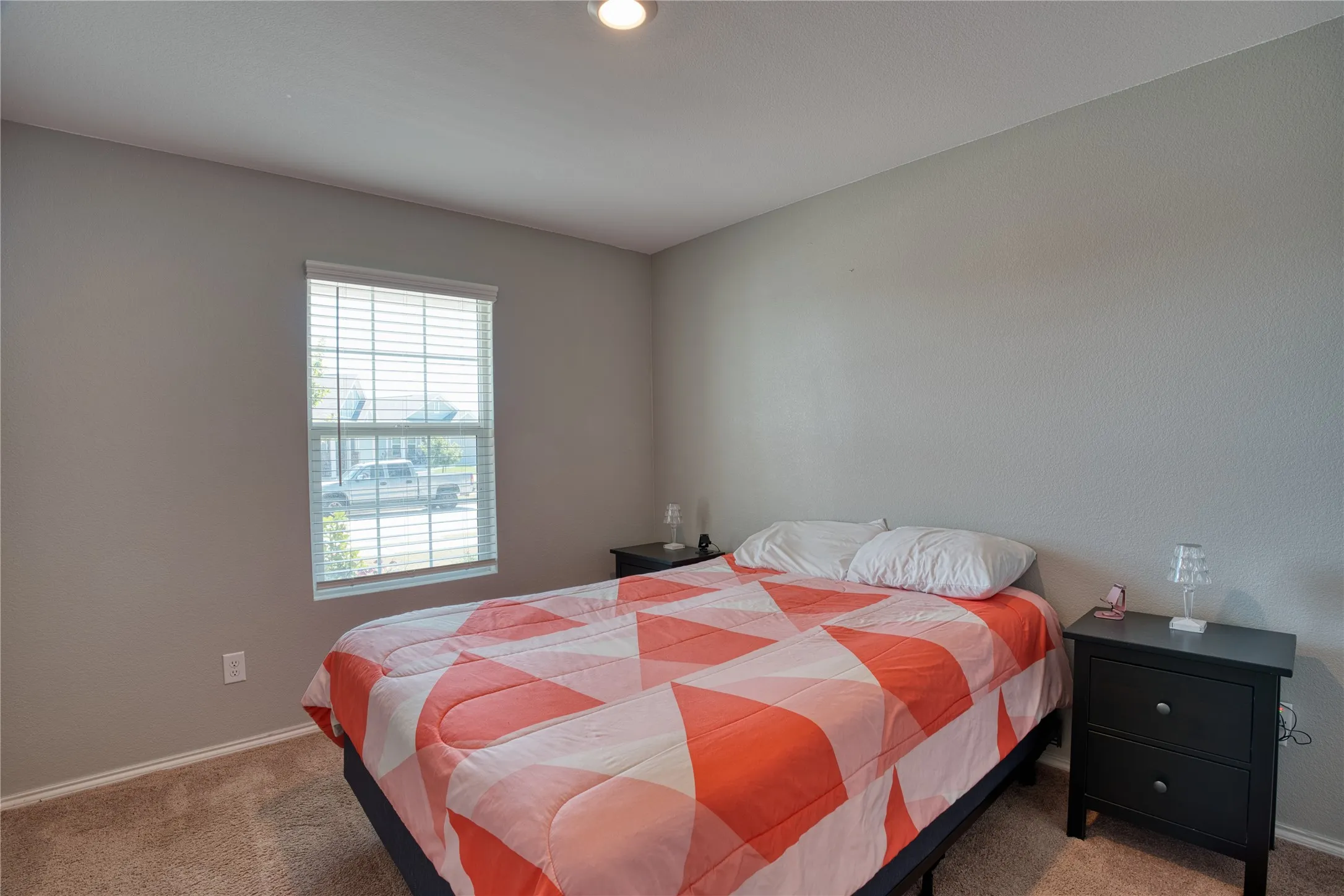 Bedroom featuring a window with blinds, neutral wall tones, and carpet flooring