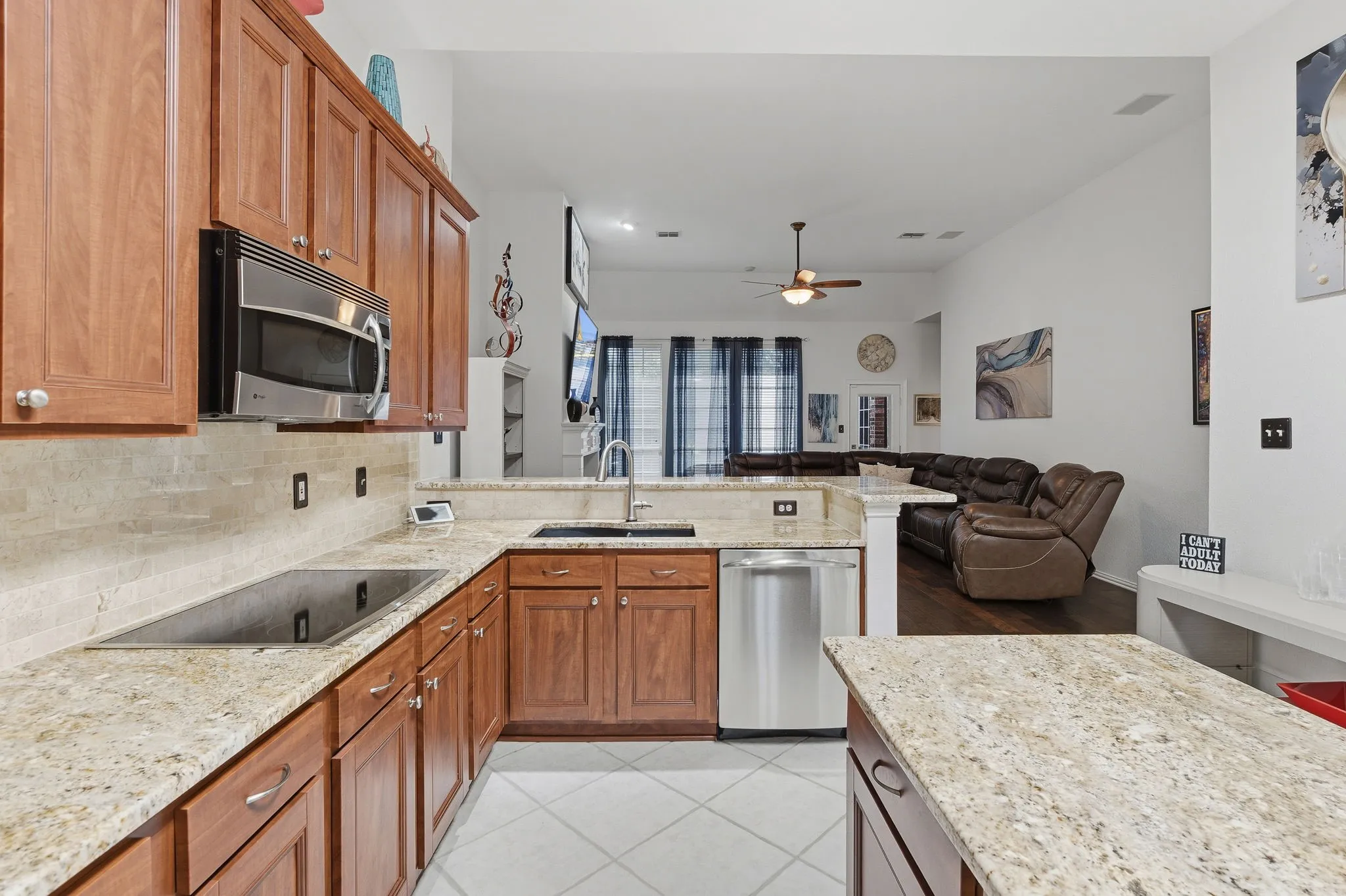 Kitchen featuring wood cabinetry, light-toned countertops, a built-in microwave, and stainless steel appliances