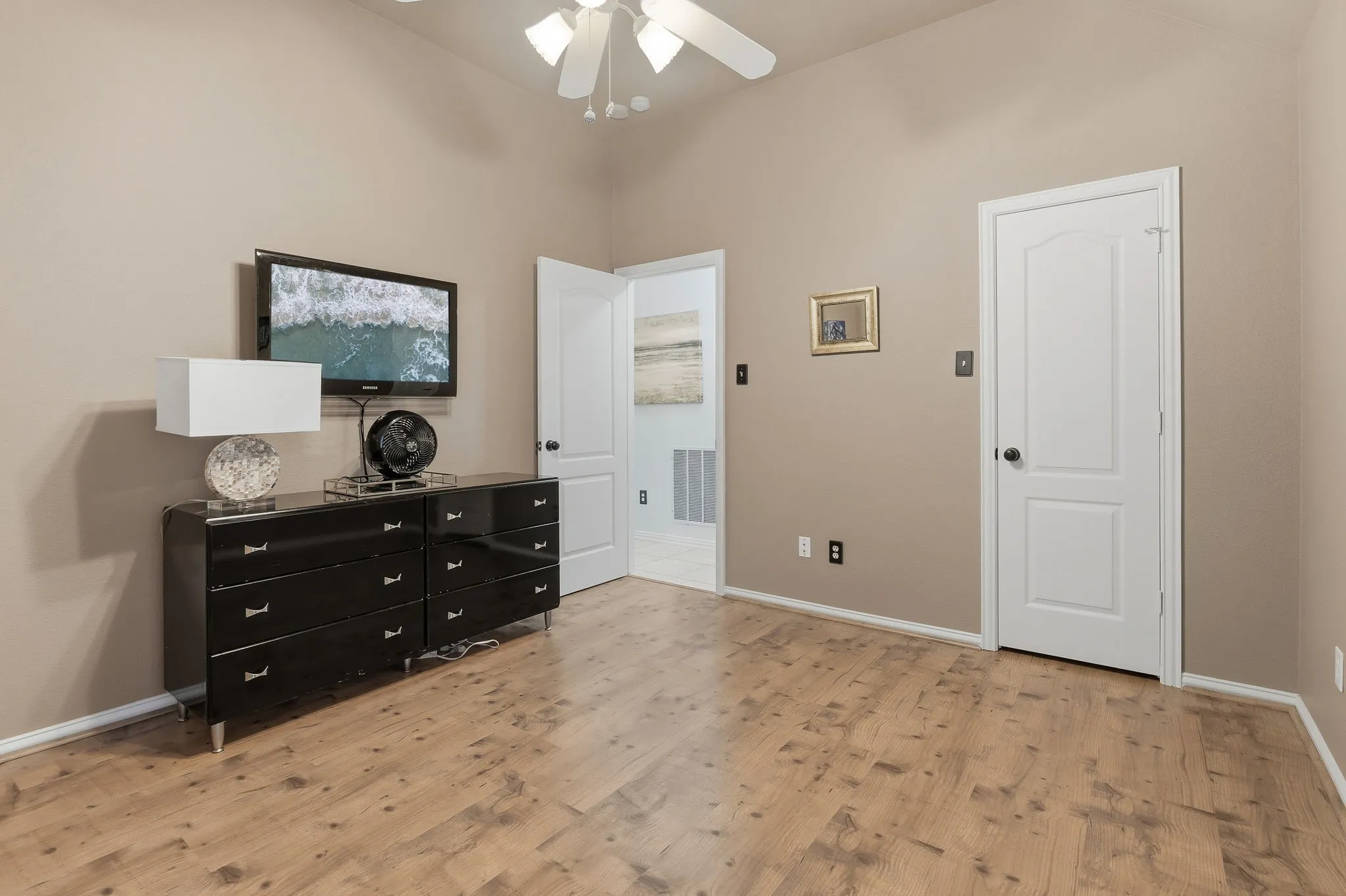 Vaulted ceilings, wood-finish flooring, and a ceiling fan with integrated lighting