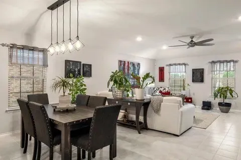 Recessed lighting with a ceiling fan, tiled flooring, multiple windows, and an open-concept living area