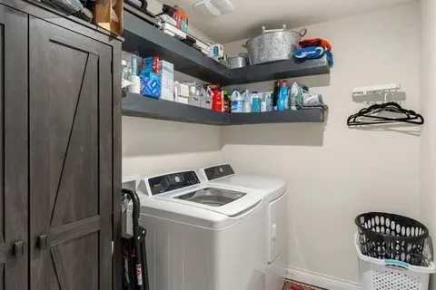 Built-in corner shelving, integrated cabinetry, and laundry appliances