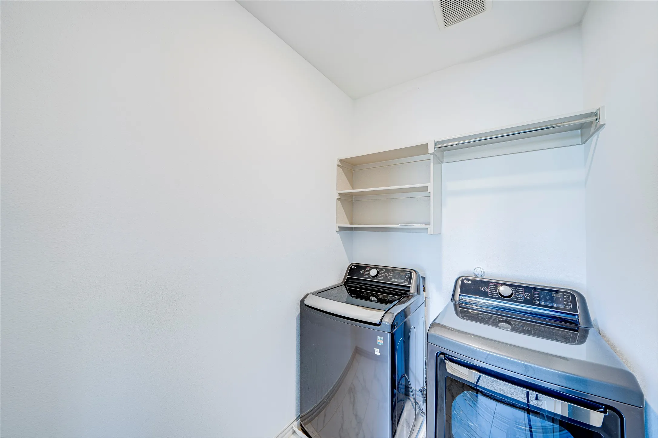 Laundry area with built-in shelving and clothes rod