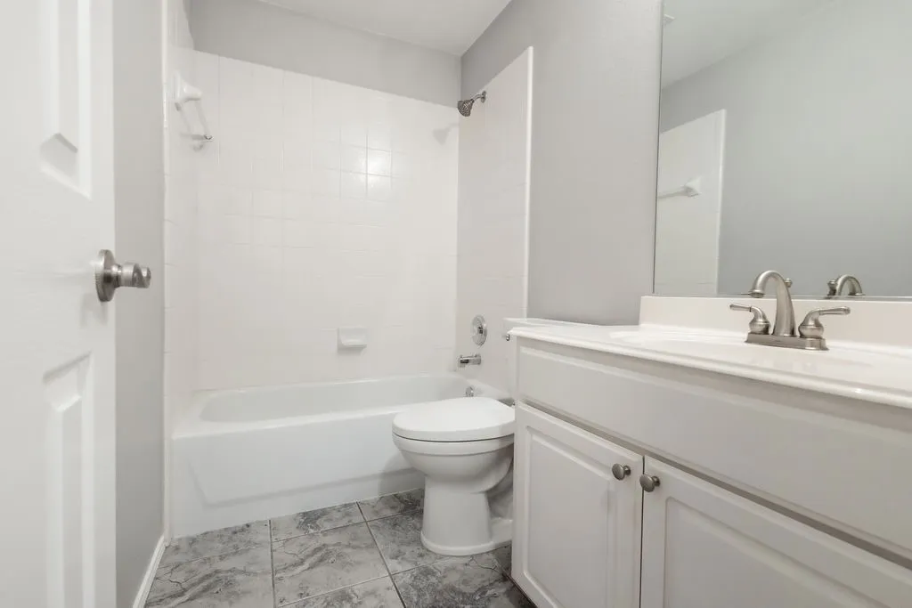 White vanity with cabinet storage, integrated sink, and brushed nickel hardware