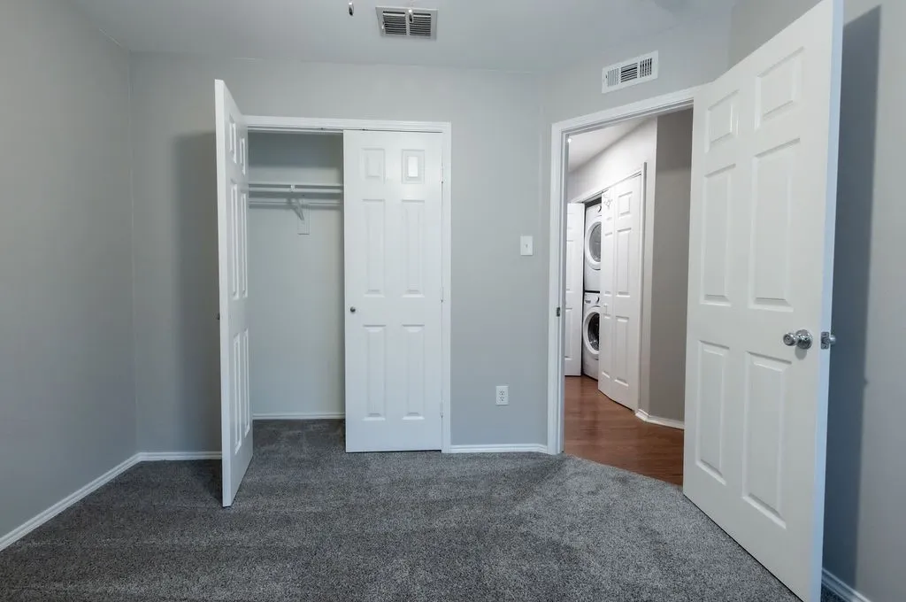 Plush carpet flooring, neutral wall paint, and a built-in closet with double doors
