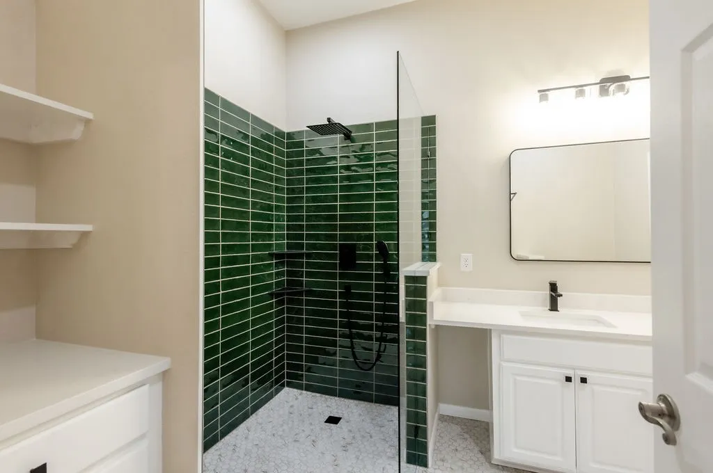 Walk-in shower with green subway tile and mosaic floor